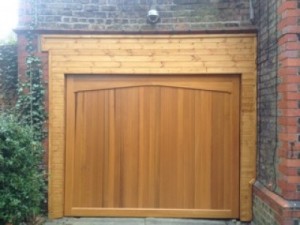 Pictures showing an old broken garage door and the replacement of a Woodrite Buckingham                     